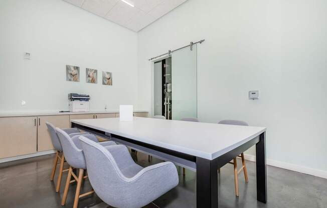 A conference room with a long table and chairs.