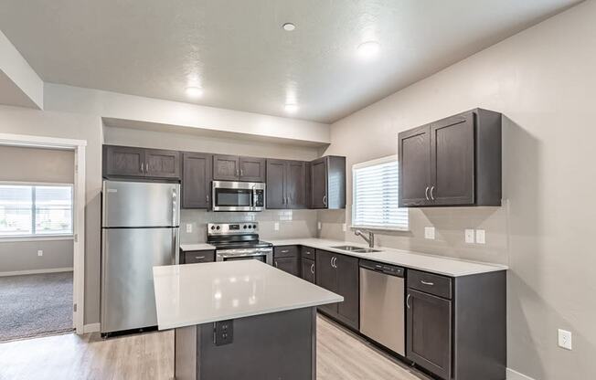 a kitchen with a large island and stainless steel appliances