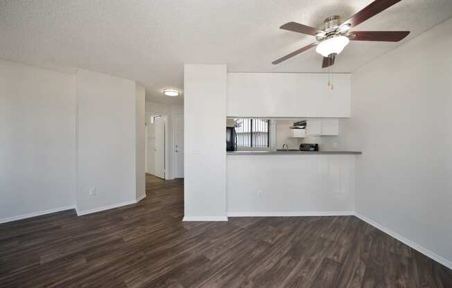 an open living room and kitchen with a ceiling fan