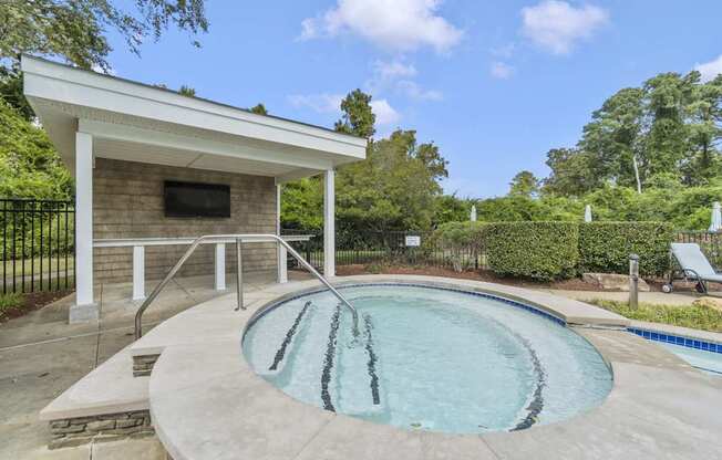 a hot tub and pool in a backyard with a pool house