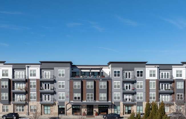 an image of an apartment building overlooking a parking lot