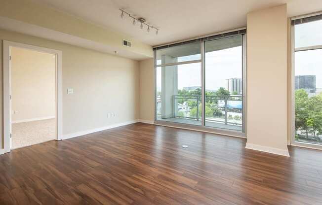 an empty living room with wood floors and a window