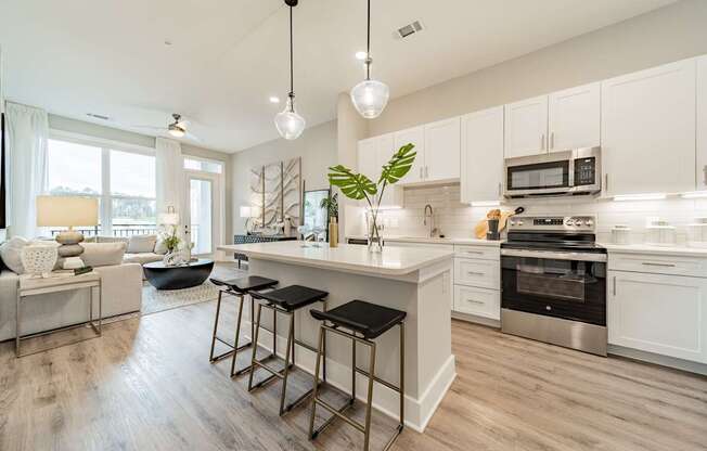 A modern kitchen with white cabinets and a large island.