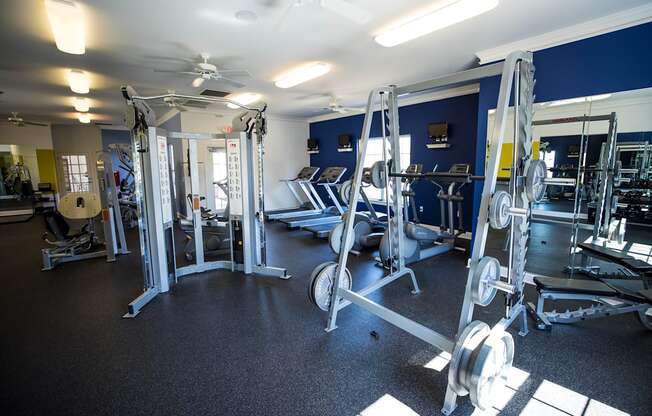A gym with a variety of weightlifting equipment.