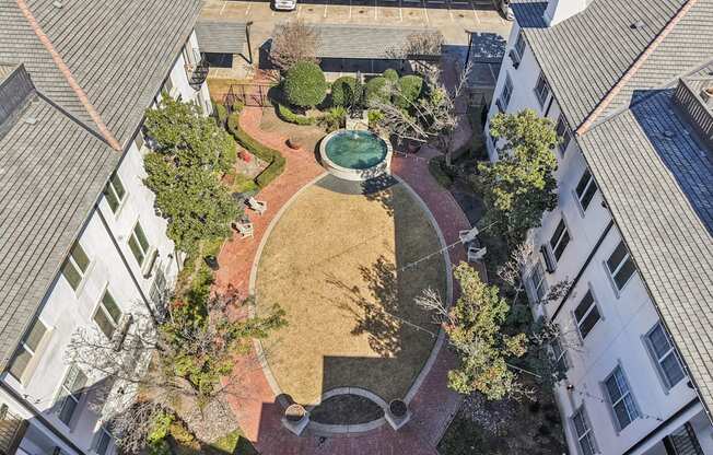 A courtyard surrounded by buildings with a fountain in the middle.