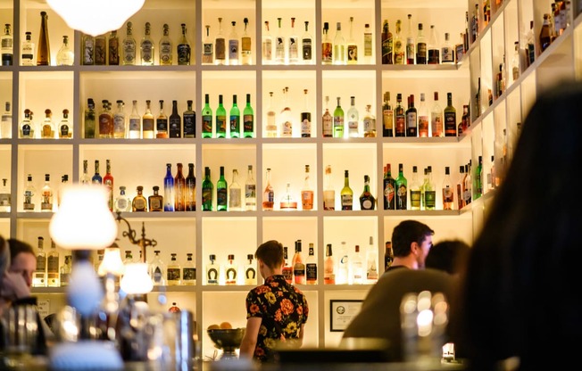 the back wall of a bar filled with bottles of alcohol