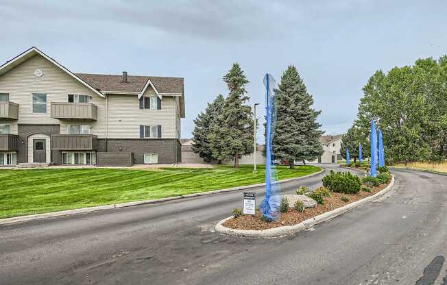 Pet-Friendly Apartments in Aurora, CO– Aurora Meadows – A road with a sign and a building in the background.