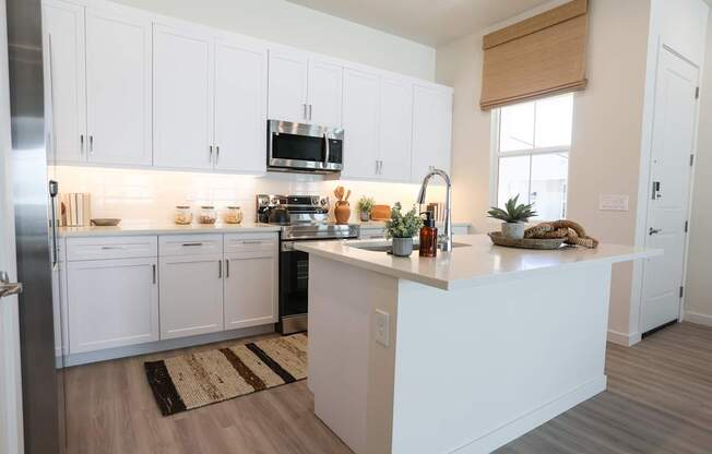 A kitchen with white cabinets and a wooden countertop.