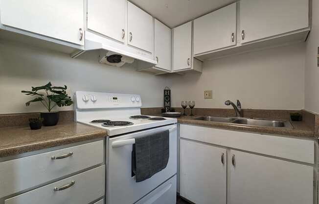 an empty kitchen with white appliances and white cabinets