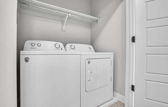 A white washing machine and dryer in a small laundry room.