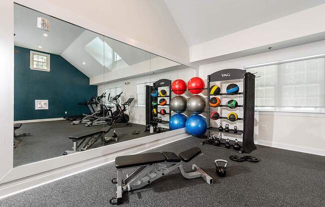 A gym room with a mirror, weights, and exercise equipment.