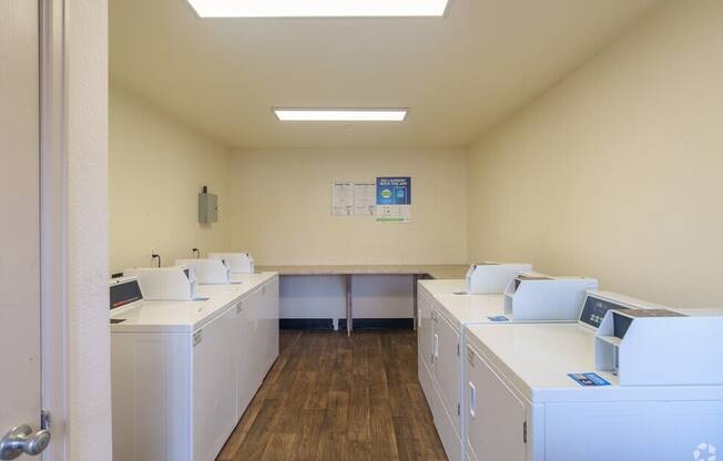 an empty room with washing machines and dryers