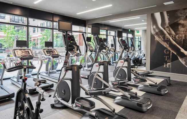 A gym with treadmills, elliptical machines, and other exercise equipment.