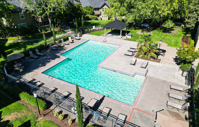 an aerial view of a swimming pool with chairs and umbrellas