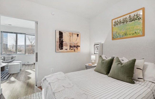 a bedroom with a bed and a bathroom with a window at Sinclaire on Seminary, Alexandria