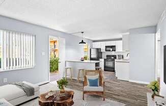A modern kitchen with white cabinets and a wooden floor.