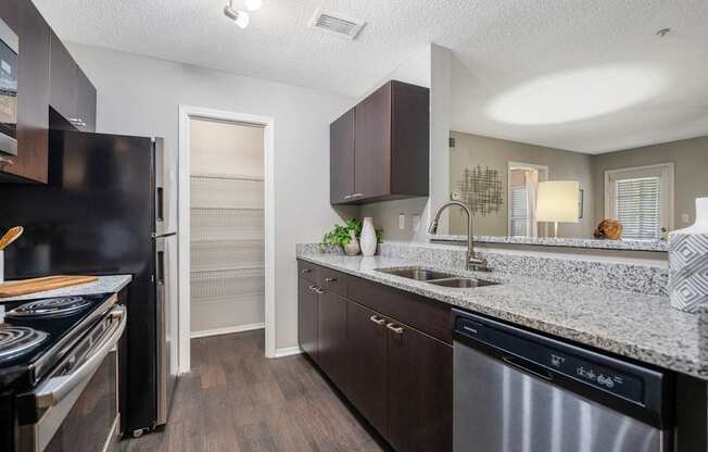 A kitchen with dark brown cabinets and a stainless steel dishwasher.
