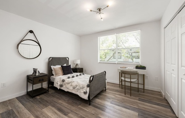 a bedroom with a bed and a desk with a chair