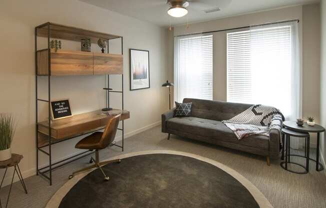 a living room with a couch and a desk and a window at Cycle Apartments, Fort Collins, CO, 80525