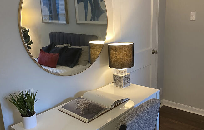 a white desk with a mirror above it in a room with a door