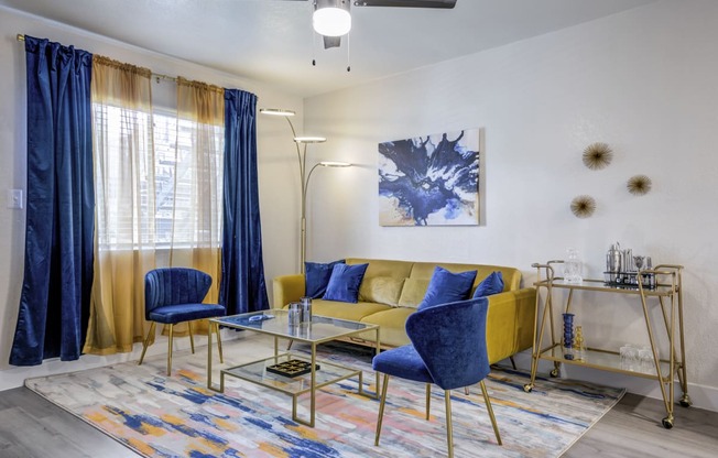 a living room with a yellow couch and blue chairs