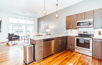 a large kitchen with wooden floors and stainless steel appliances at 20 Midtown, Birmingham, 35233