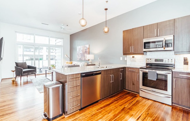 a large kitchen with wooden floors and stainless steel appliances at 20 Midtown, Birmingham, 35233