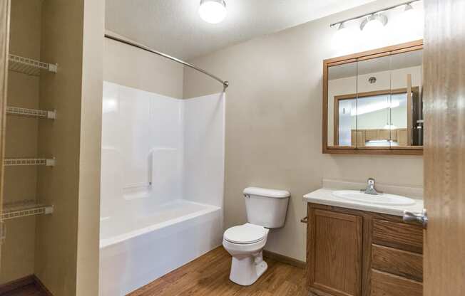 Bathroom with a shower toilet sink and mirror at Sunset Ridge Apartments in Bismarck, 58503 ND