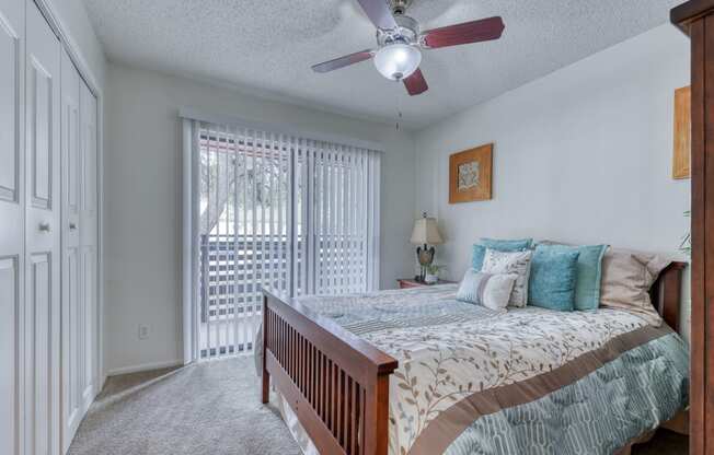 a bedroom with a bed and a ceiling fan