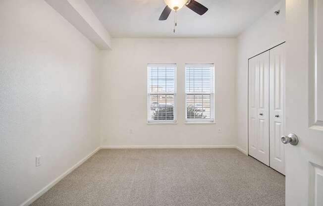 A bedroom with a ceiling fan and two windows at Lynbrook Apartments and Townhomes, Elkhorn, NE, 68022