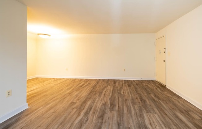 a bedroom with hardwood floors and white walls