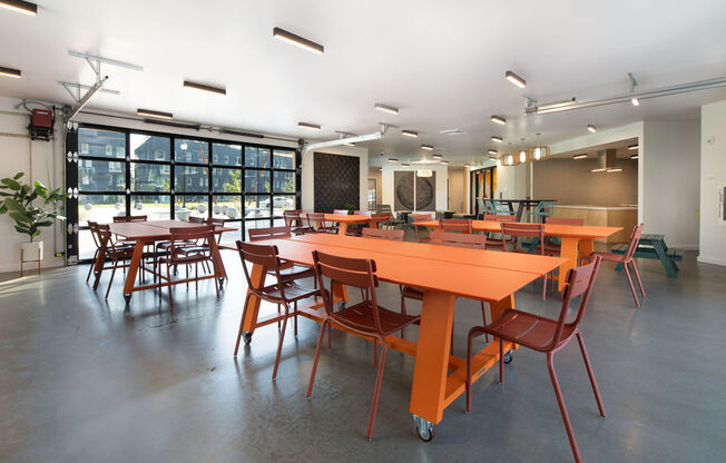 a large room with orange tables and chairs