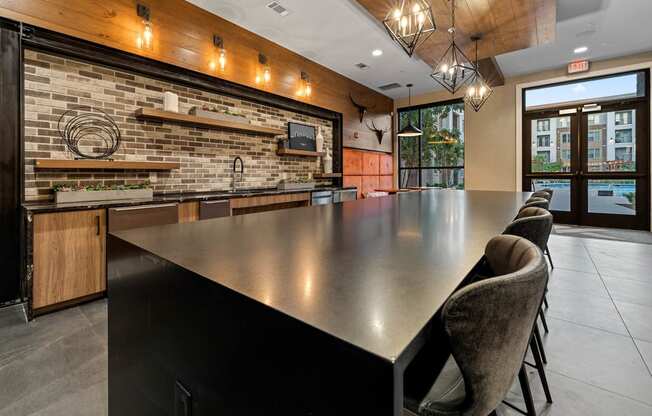 a large kitchen with a long counter and chairs