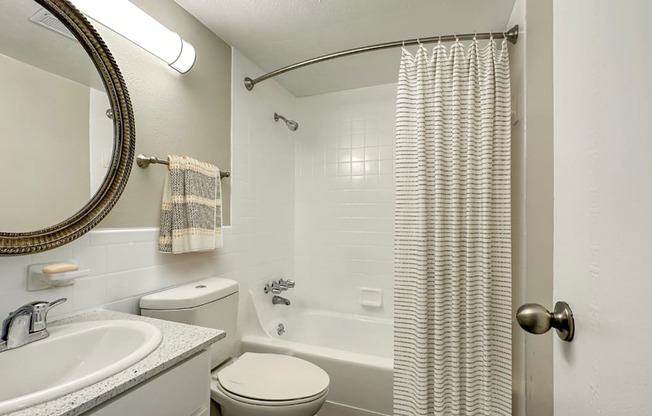 A bathroom with a toilet, sink, and shower.