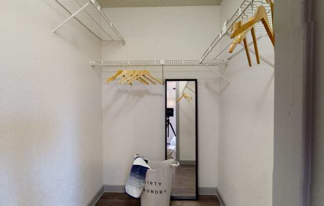 a hallway with bags and clothes hanging from the ceiling and a mirror