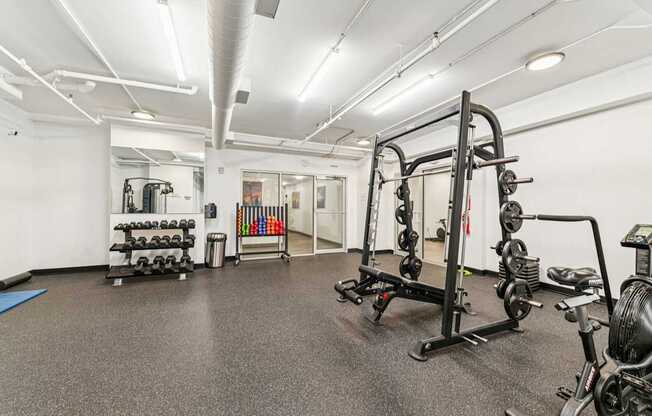 A gym with a variety of equipment including weights and exercise machines.