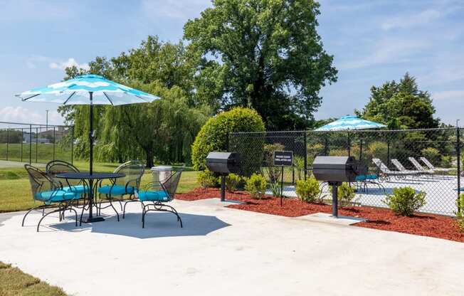 a patio with chairs tables and umbrellas and a pool