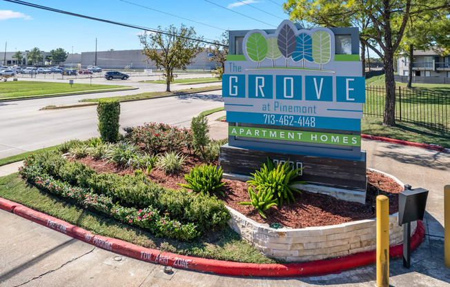 A sign for The Grove apartment homes sits in front of a landscaped area.