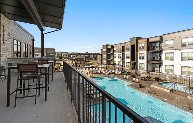 a resort style pool with tables and chairs on a balcony