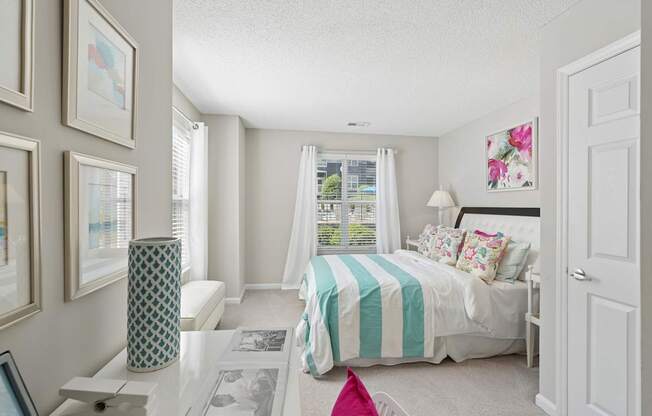 A bedroom with a bed, nightstand, and pictures on the wall.