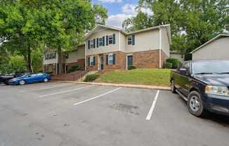 A car is parked in a parking lot in front of a building.