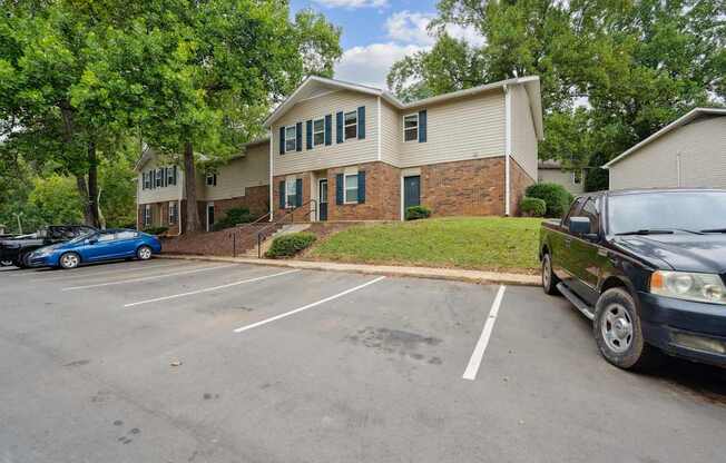 A car is parked in a parking lot in front of a building.