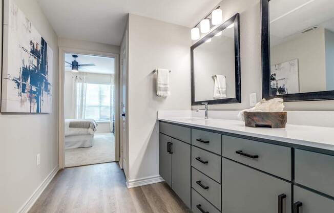 A bathroom with a large mirror and a painting on the wall.
