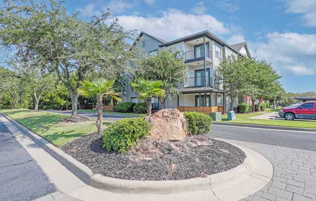 Main entrance road with median and apartment buildings in the background at Ultris Island Park in Shreveport, LA
