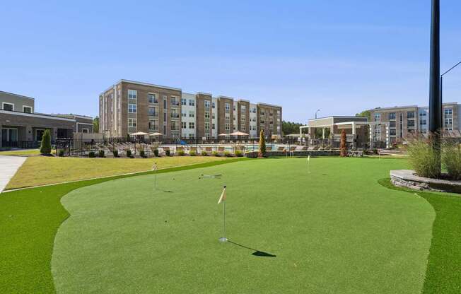A golf course with a green lawn and a flag on the green.