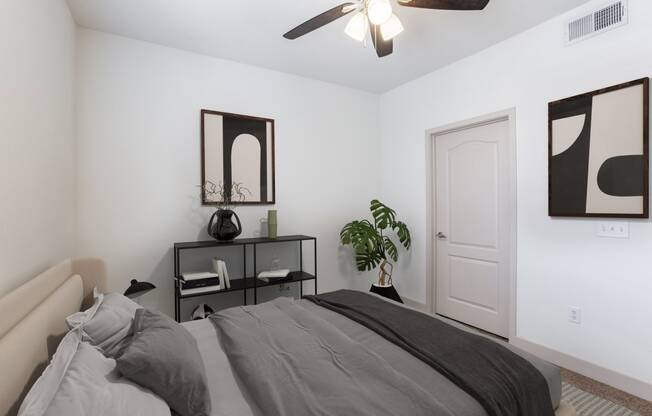 a bedroom with a large bed and a ceiling fan