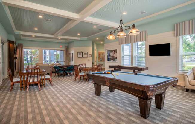 a game room with a pool table and tables