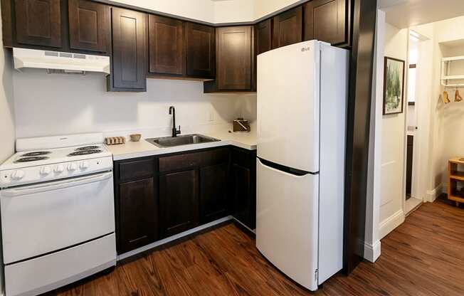 a kitchen with white appliances and dark wood cabinets