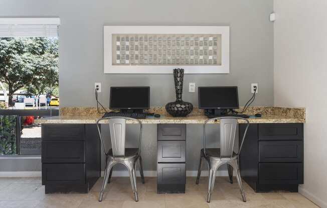 a computer desk with two computers on it in a room