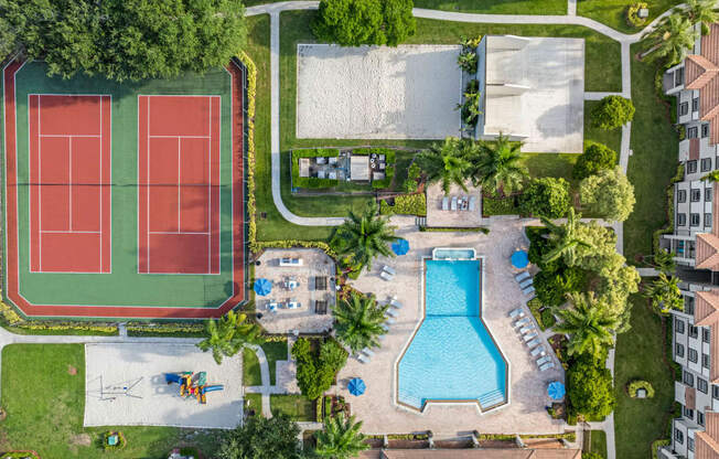 a birdseye view of a tennis court and a swimming pool in a backyard